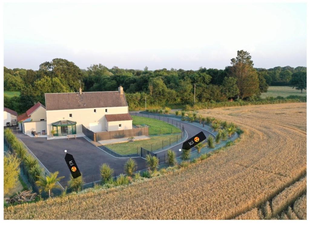 une vue aérienne sur une maison et un champ dans l'établissement Gîte Cottage, cosy entre terre et mer, à Vesly
