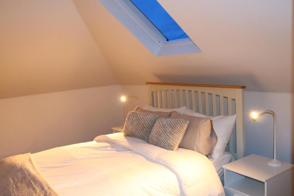 1 dormitorio con 1 cama con tragaluz en OPULENT HOUSE London, en Dagenham
