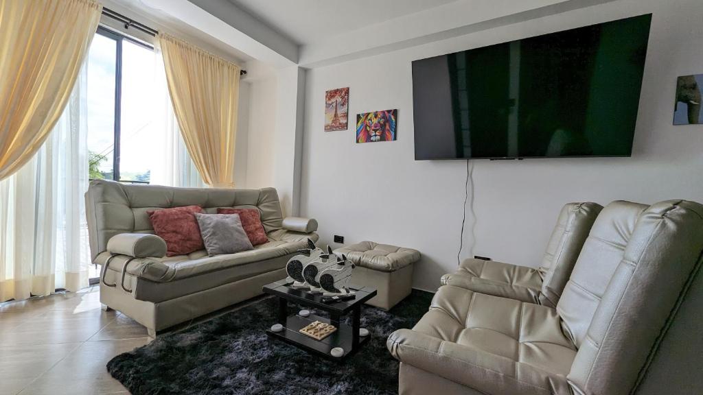 sala de estar con 2 sofás y TV de pantalla plana en Moderno Apto familiar piso 3, en Santa Rosa de Cabal