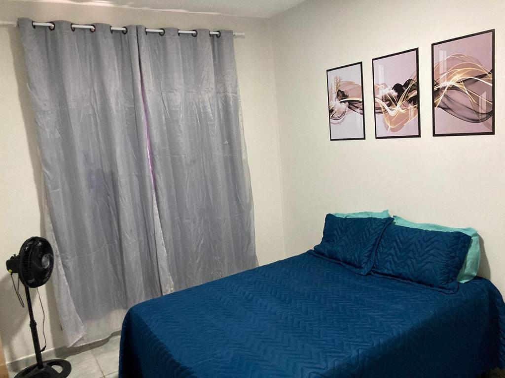 Un dormitorio con una cama azul y una ventana en Lindo apartamento na Praia do Morro, en Guarapari