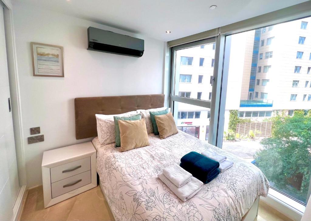 a bedroom with a bed with a large window at Luxury 1 Bed - City Suites Ocean Spa Plaza in Gibraltar