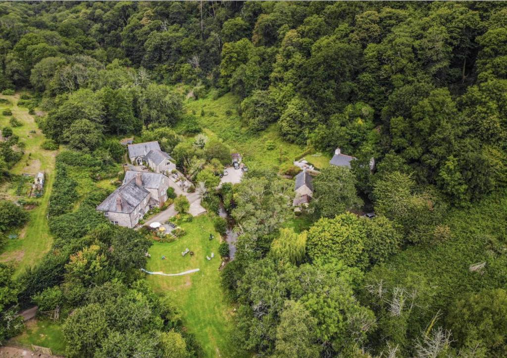 an aerial view of a house on a hill with trees at Watermill Cottages - 18th Century converted Mill 10 mins from beach in Dartmouth