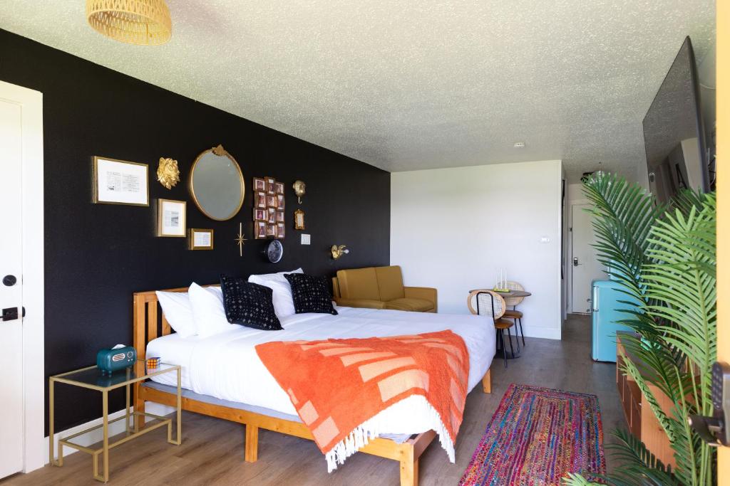 ein Schlafzimmer mit einem weißen Bett und einer schwarzen Wand in der Unterkunft Hotel McCoy - Art, Libations, Pool Society in College Station