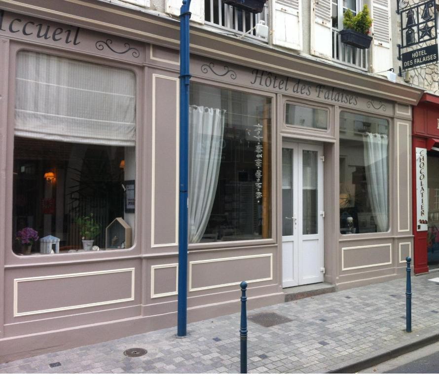 a store front with a blue pole in front of it at Hotel Des Falaises in Villers-sur-Mer