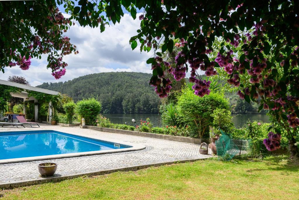 a swimming pool with a view of a lake at Casa do Pombal in Medas