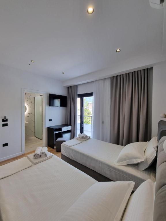 a hotel room with two beds and a television at White Villa in Përmet