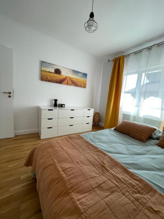 a bedroom with a large bed and a dresser at Bliss Râșnov in Râşnov