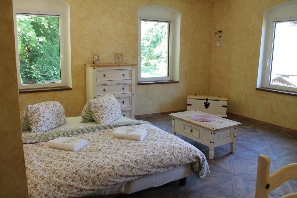 a bedroom with two beds and a table and two windows at Hrad Vildstejn in Skalná