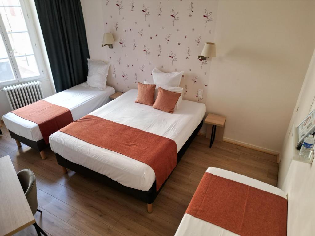 two beds in a hotel room with two beds at Hôtel les Platanes in Villeneuve-sur-Lot