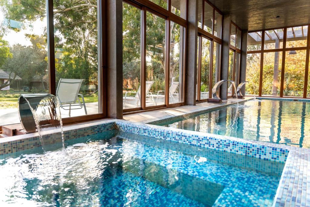 a swimming pool with a view of a house at O2 Hotel Valeria del Mar in Valeria del Mar