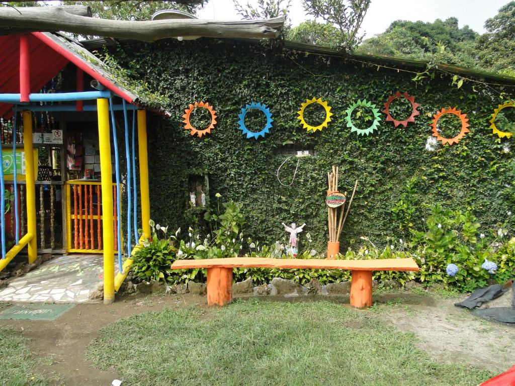 a bench in front of a green wall with wreaths at Finca Ecoturística Tierra Blanca in La Laja