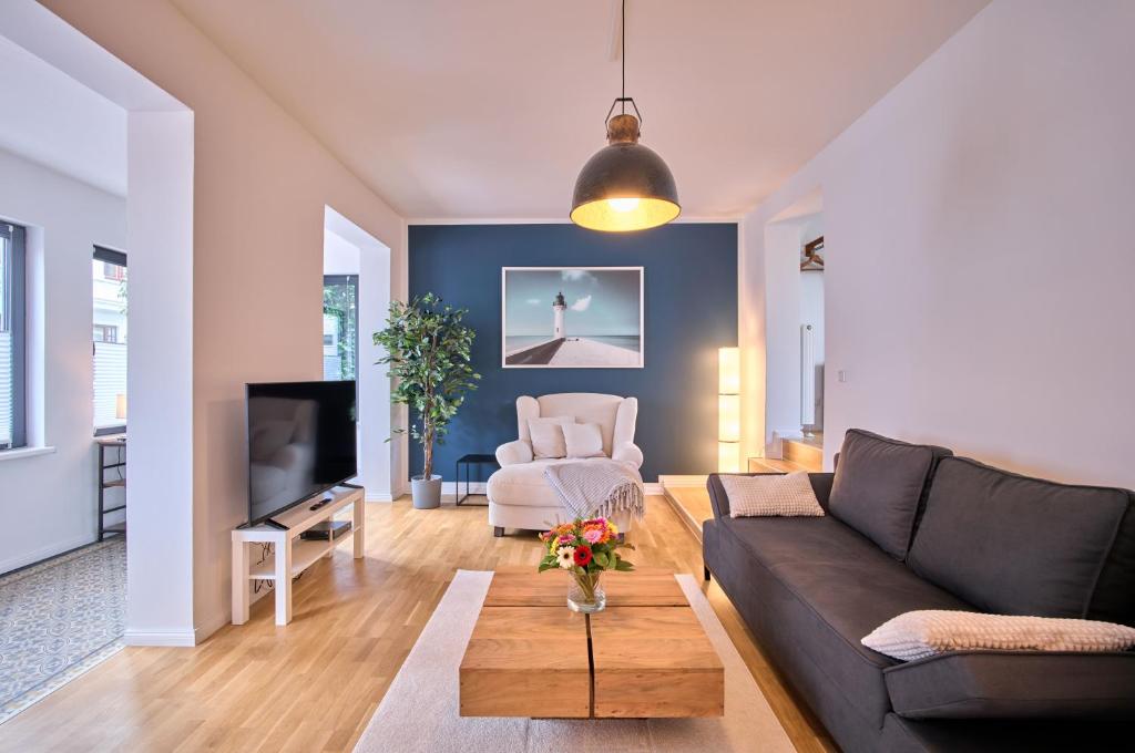 sala de estar con sofá y TV en Charmante Altbremer Wohnung I Wintergarten I Küche I Balkon, en Bremen