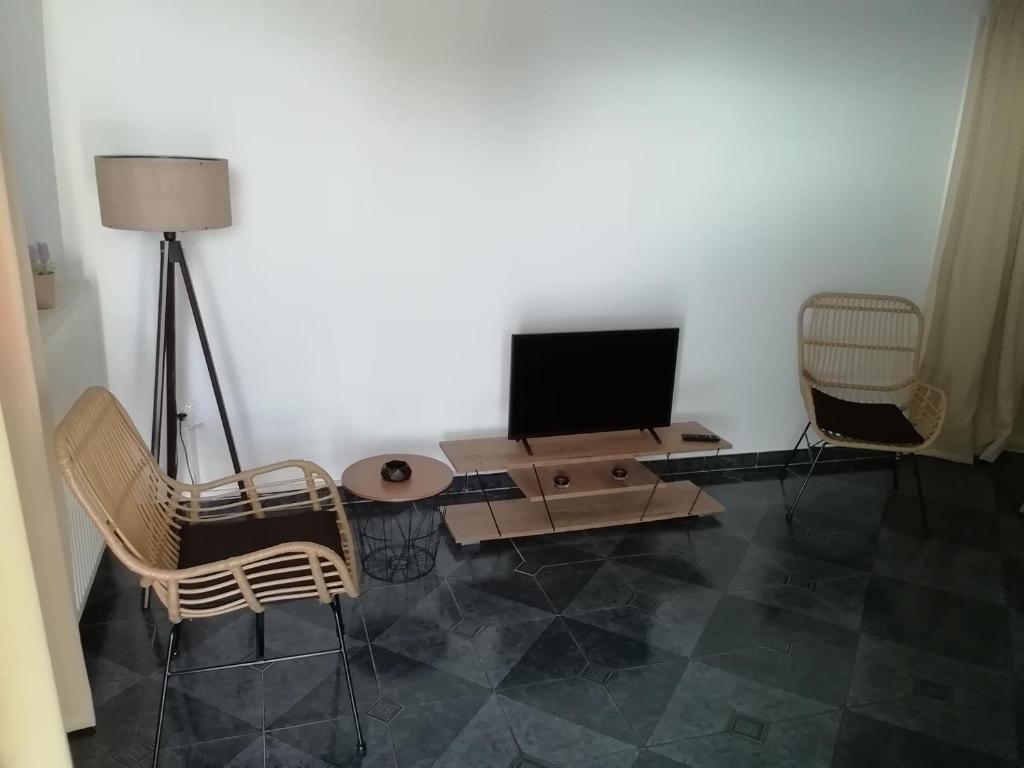 sala de estar con TV, mesa y sillas en Andros Breeze, en Batsi