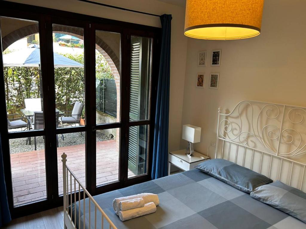 ein Schlafzimmer mit einem Bett und einem großen Fenster in der Unterkunft Casa Tea in Lucca