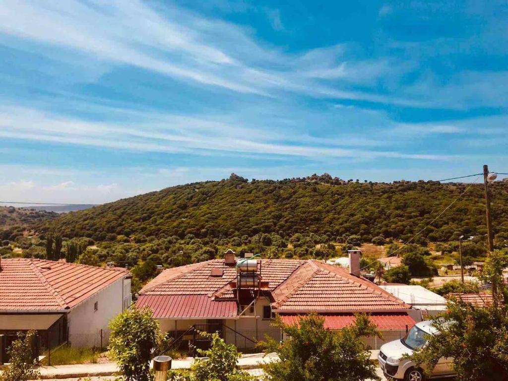 Gokceada Town的住宿－Denize 2 km Manzaralı ve Ferah 2+0 Daire (Konum Eşelek Köyü)，享有房屋屋顶和山脉的景色