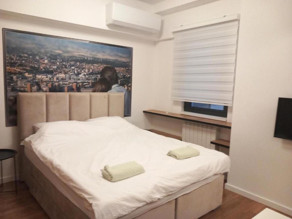 a bedroom with a bed with two towels on it at Zeirene in Skopje