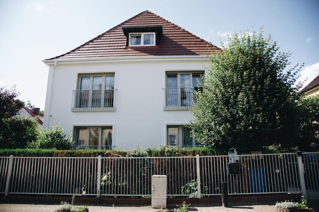 a white house with a fence in front of it at powiew in Świnoujście