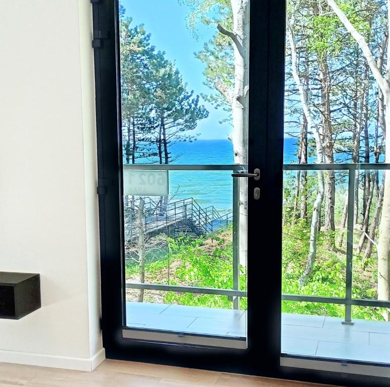 a door with a view of the ocean at SEA & YOU Apartament z widokiem na morze - Dwie Sosny in Ustronie Morskie