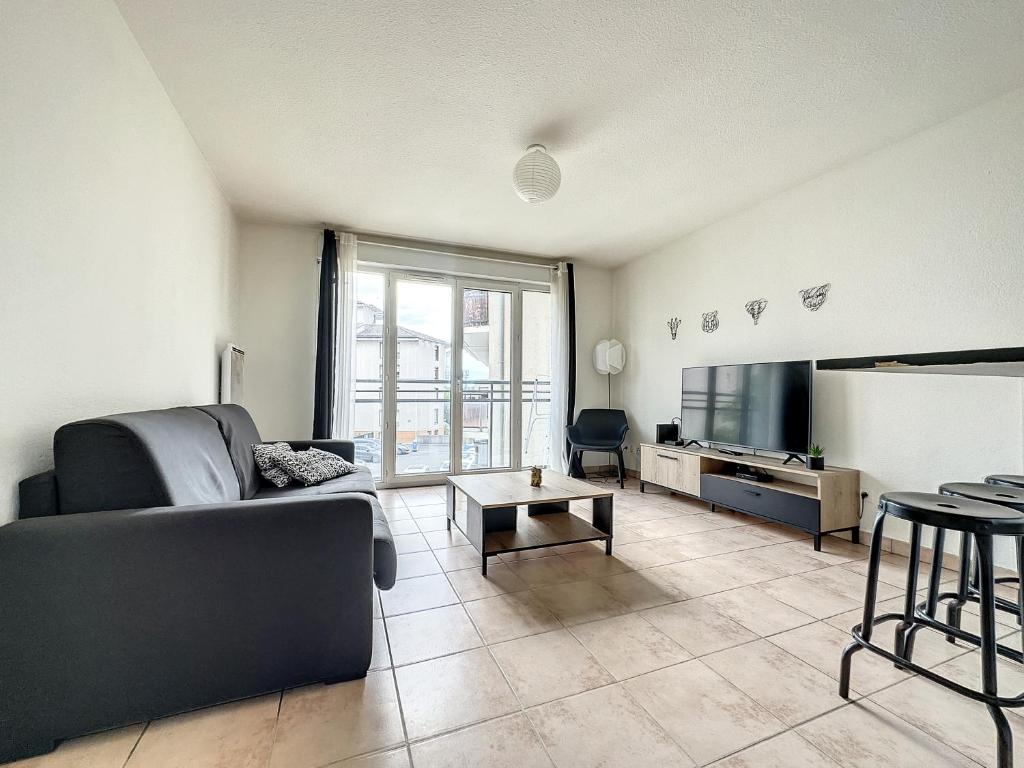 a living room with a couch and a flat screen tv at Gare Annemasse Proche GENEVE in Annemasse