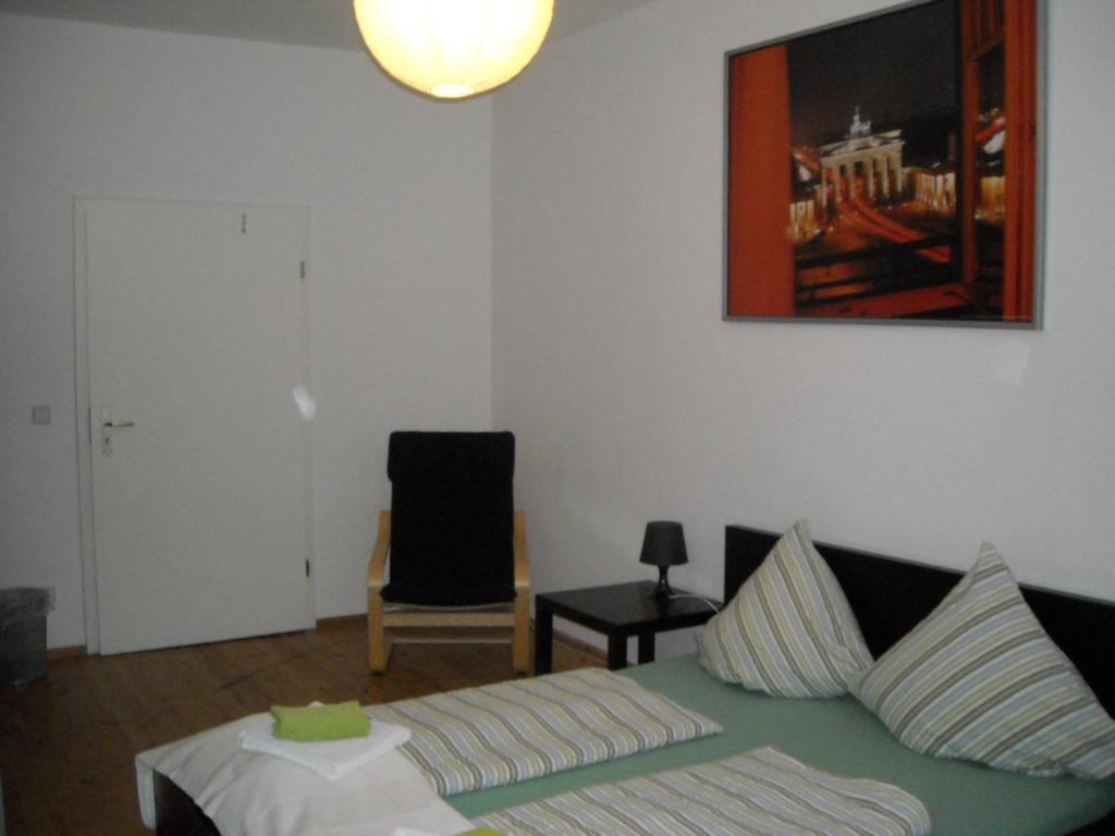 ein Wohnzimmer mit einem Bett und einem Stuhl in der Unterkunft Pension Mitte in Berlin