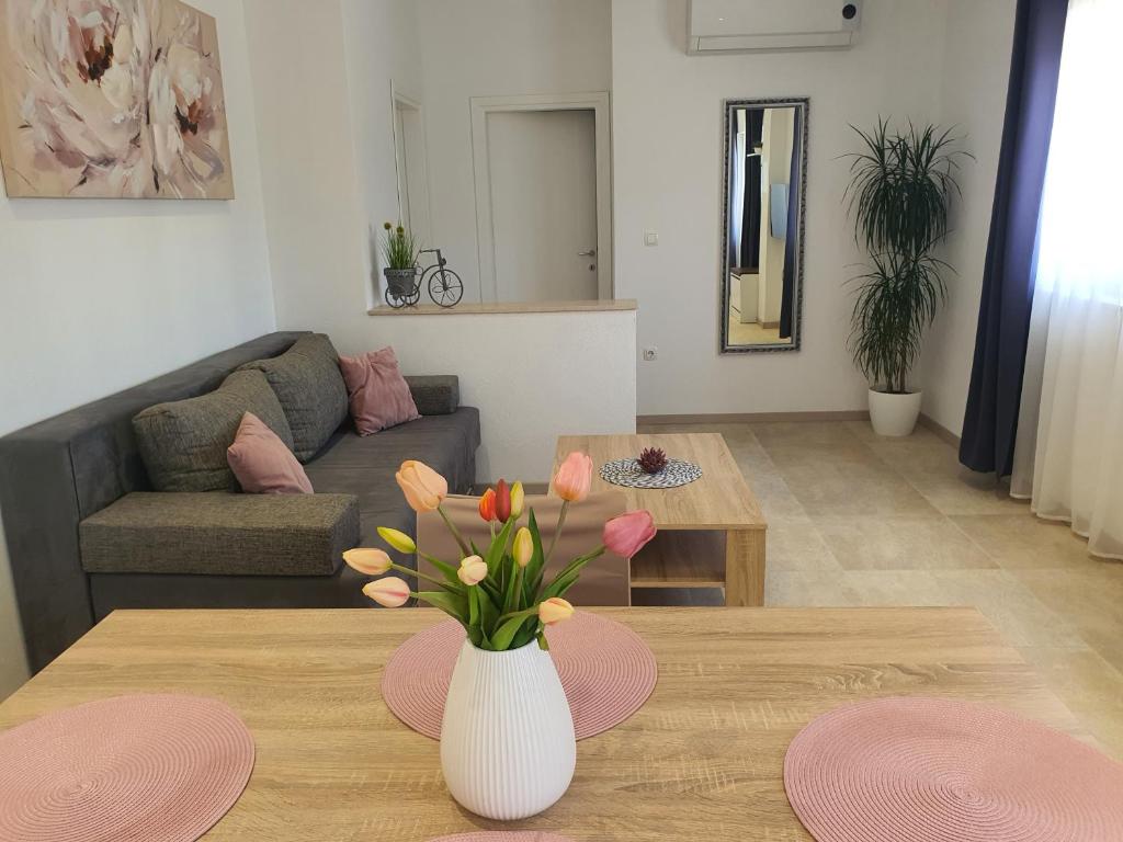 a living room with a vase of flowers on a table at Apartment Radoš in Dugopolje