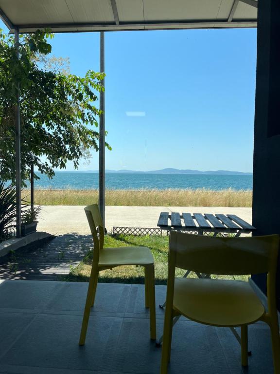 a table and two chairs and a view of the ocean at Aliara Dilara Beach Apartments in Pomorie