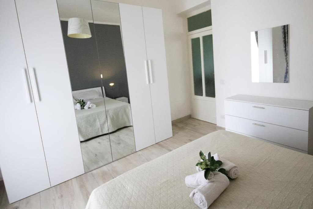 una camera da letto con specchio e asciugamani sul pavimento di Ovidio home a Palermo