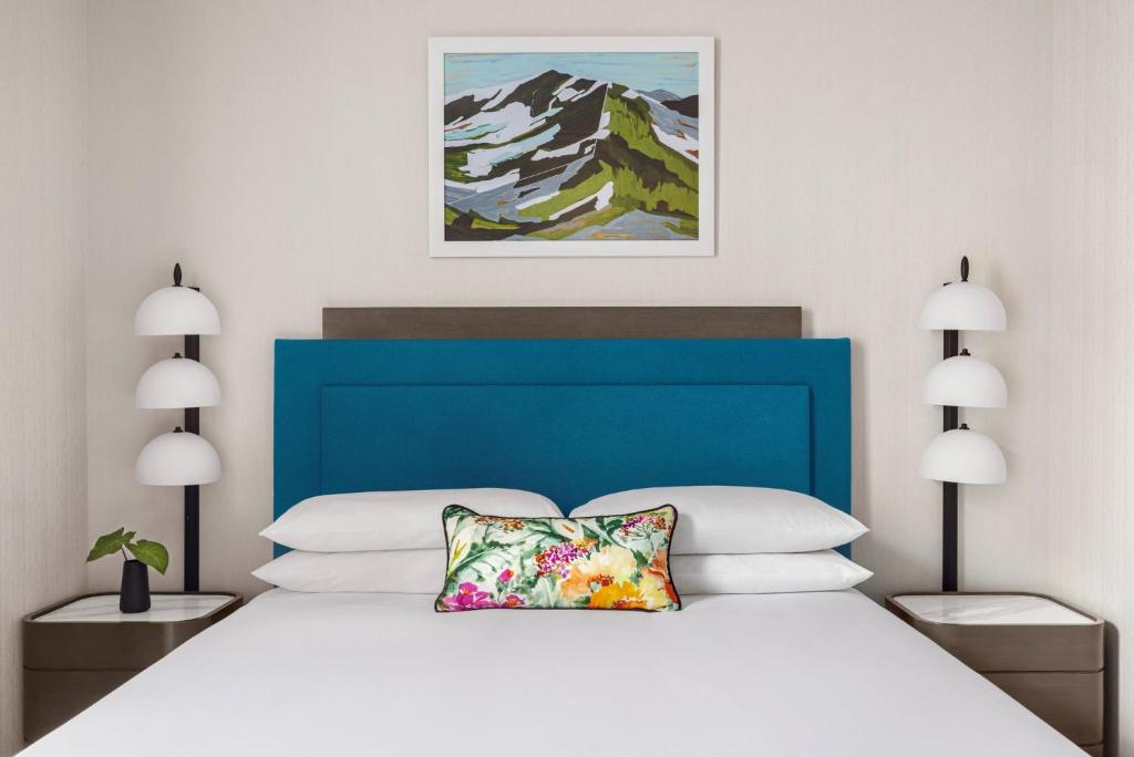 a bedroom with a large white bed with a blue headboard at Kimpton Hotel Monaco Salt Lake City, an IHG Hotel in Salt Lake City
