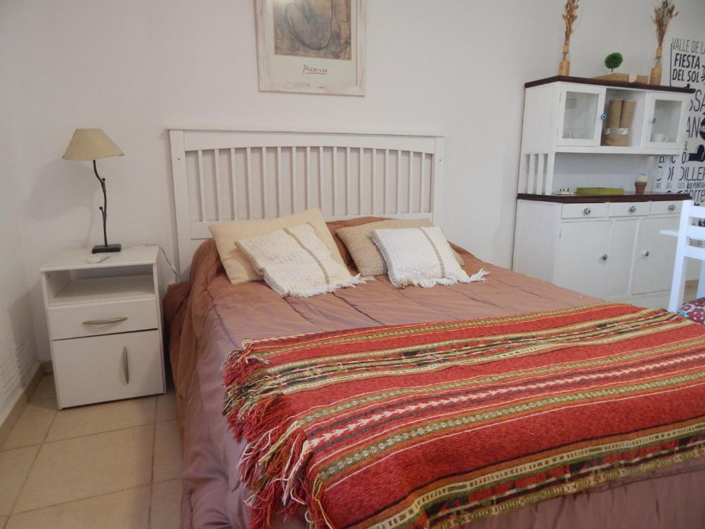 Un dormitorio con una cama grande con una manta. en Departamento Zona Residencial. wiffi. cochera en San Juan