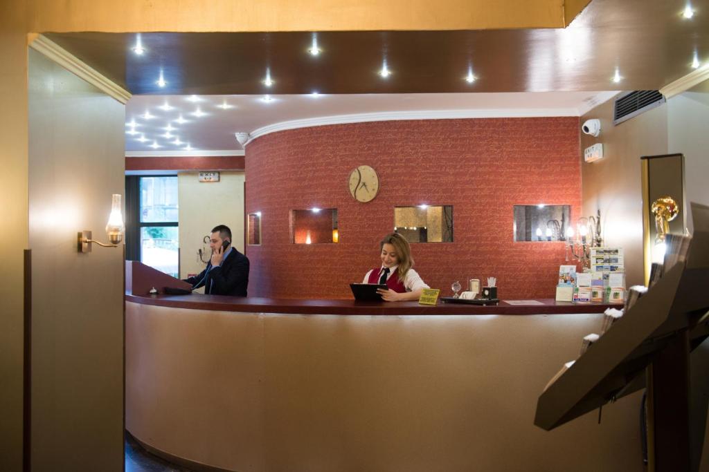 Un uomo e una donna seduti al bar di Delphi Art Hotel by Prima Hotels ad Atene