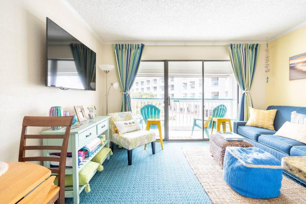 ein kleines Wohnzimmer mit einem blauen Sofa und einem Tisch in der Unterkunft GypSEA Blu Beach Condo Steps to the Beach in Galveston