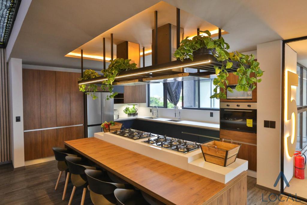 A shared kitchen with a long wooden island and built-in cooking facilities.