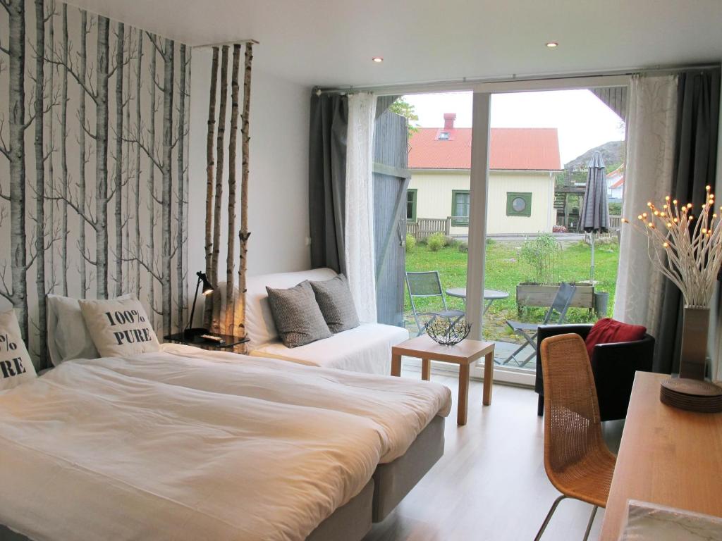 1 dormitorio con 1 cama grande y balcón en Nösundsgården Hotell & Vandrarhem, en Nösund