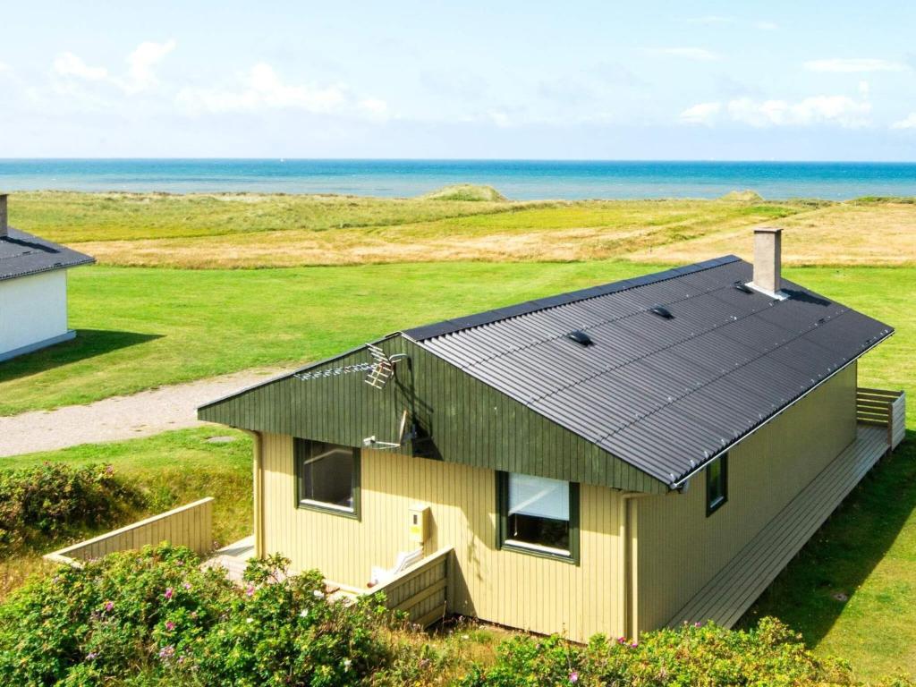 a small house with a solar roof on the beach at 6 person holiday home in Lemvig in Trans