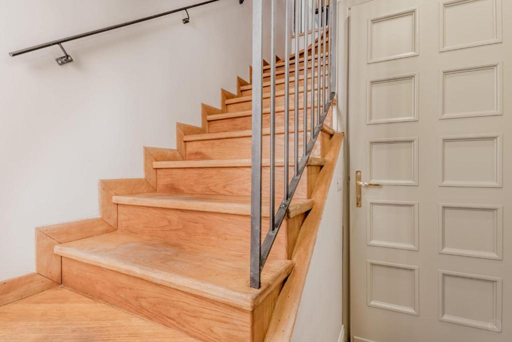 a wooden staircase with a metal railing next to a door at APT ROME - Vittoria Palace in Rome