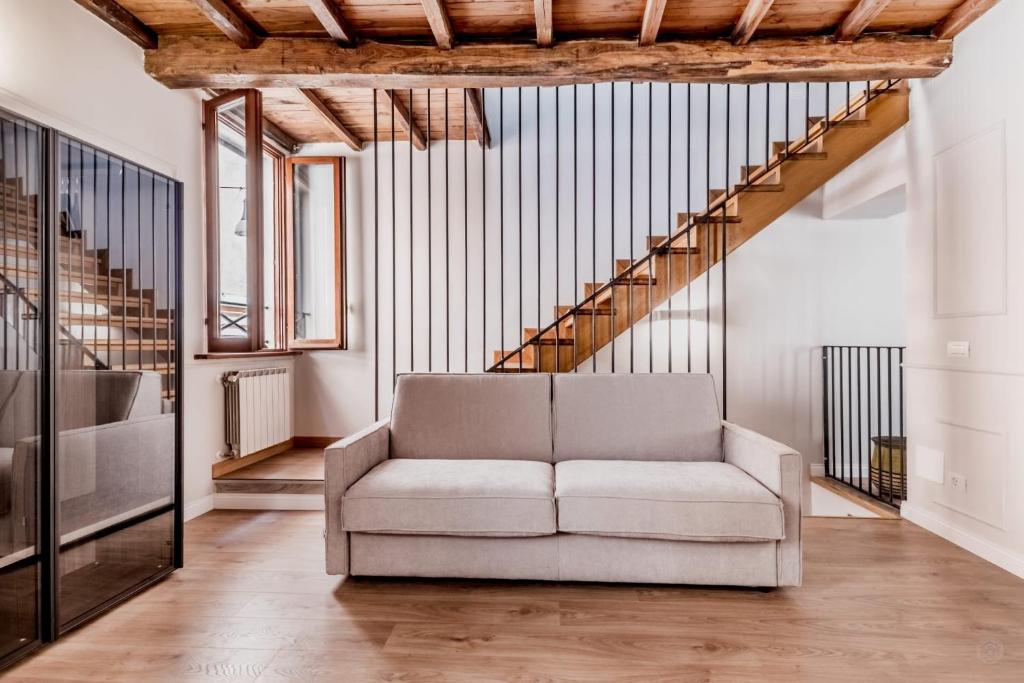 a living room with a couch and a staircase at APT ROME - Vittoria Palace in Rome