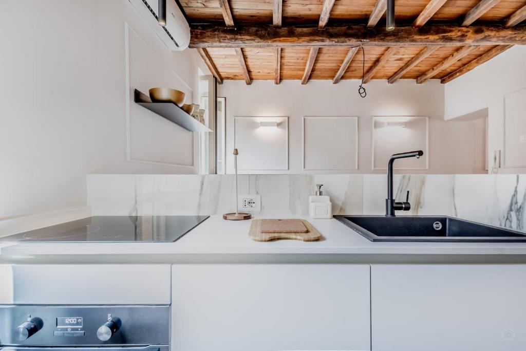 a kitchen with white cabinets and a sink at APT ROME - Vittoria Palace in Rome
