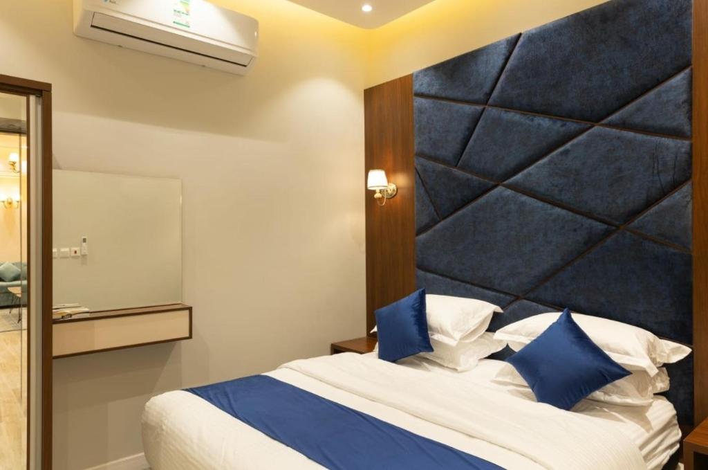 um quarto com uma cama grande e almofadas azuis em شاليهات ريفي em Riyadh