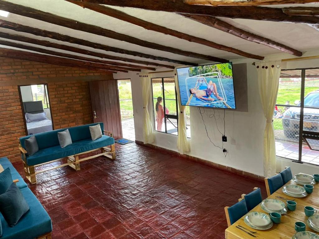 sala de estar con sofá y TV en la pared en Casa campestre Ubate, en Ubaté
