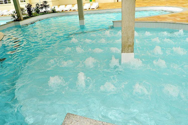 una piscina con nubes falsas en el agua en Via Caldas Exclusive, en Caldas Novas