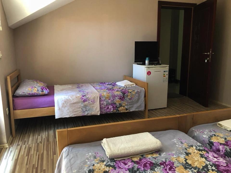 a room with two beds and a television at Struga-Rooms/Dhoma/Sobi in Struga