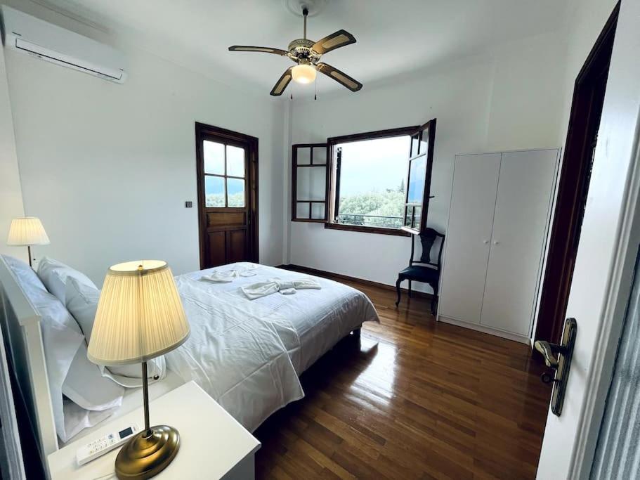 Schlafzimmer mit einem Bett und einem Deckenventilator in der Unterkunft Orange Blossom Villa in Nafpaktos