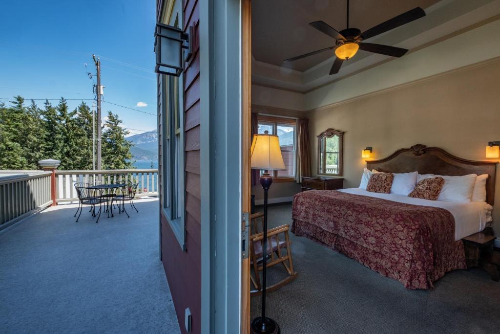 a bedroom with a bed and a balcony at Kaslo Hotel in Kaslo