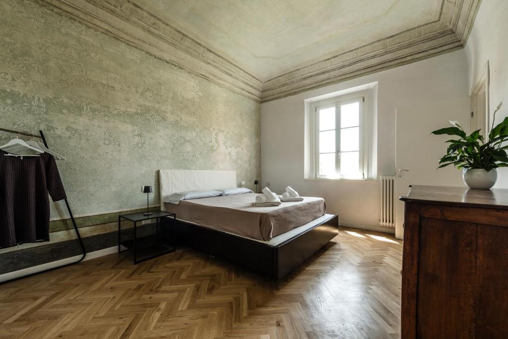 a large bedroom with a bed and a window at La Camera Verde in Pisa