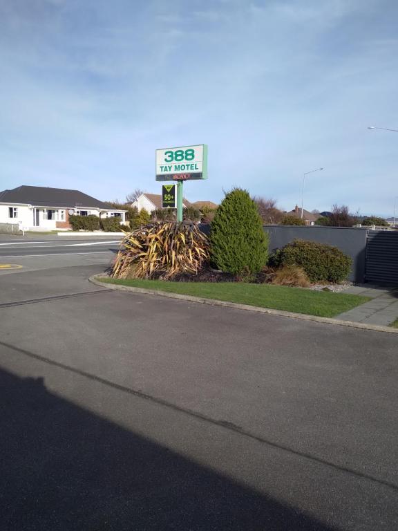 una señal de gasolinera al lado de una calle en 388 Tay Motel en Invercargill