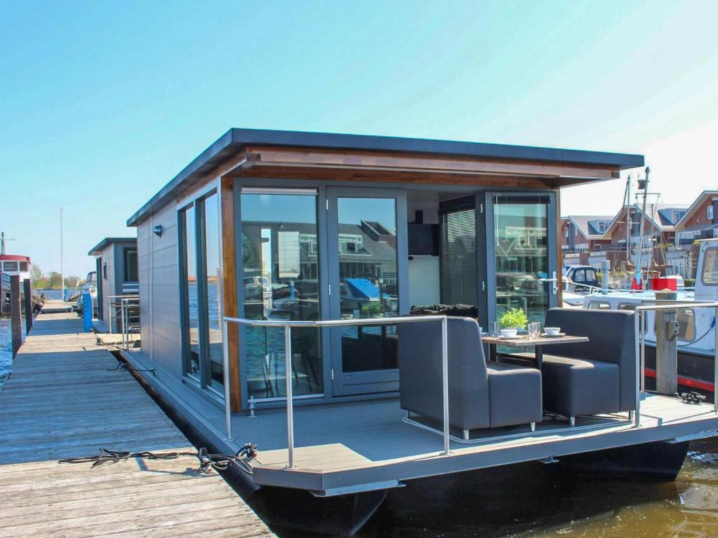 a small house on a boat in the water at Tiny houseboat Parel I - airco in Uitgeest