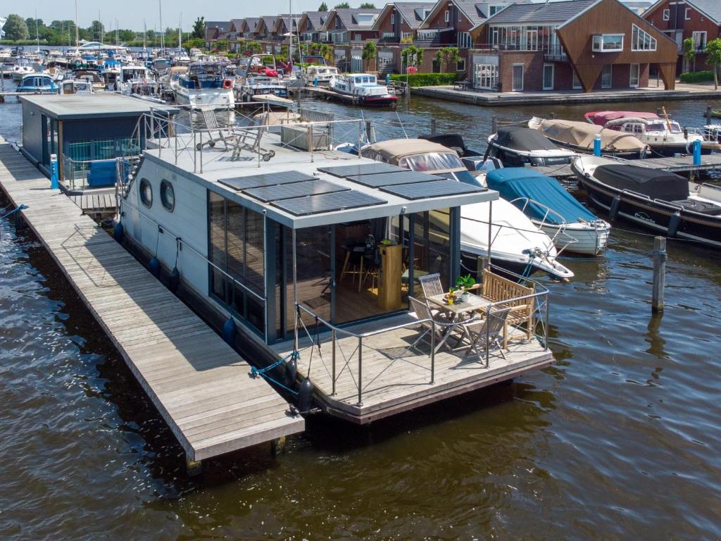 a boat is docked at a dock in the water at Tiny Houseboat De Woudaap - I in Uitgeest