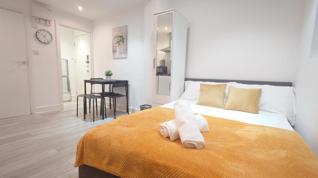 a bedroom with a bed with a towel on it at Deluxe Camden Studio Apartments in London