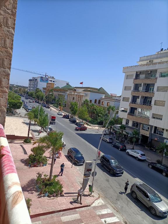 una calle de la ciudad con coches aparcados en la carretera en Jolie appartement en Kenitra