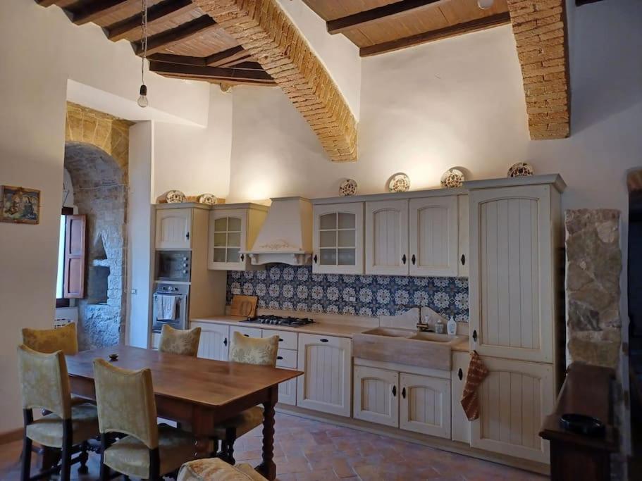 een keuken met witte kasten en een houten tafel bij Charming apartment in medieval tower in Spoleto